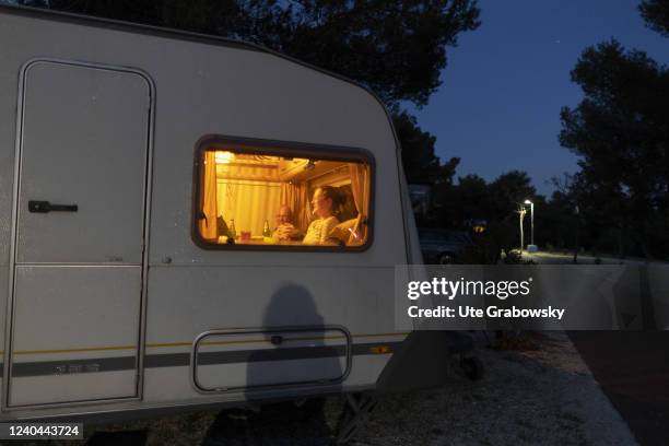 In this photo illustration people are sitting in a camper at night