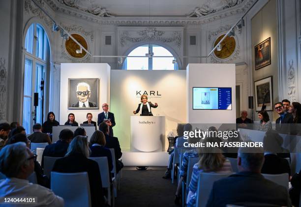 Auctioneer Caroline Lang gestures during the auction of German fashion designer, photographer and costume designer Karl Lagerfeld's personal items at...