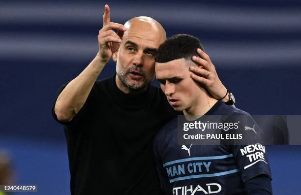 Manchester City's Spanish manager Pep Guardiola hungs Manchester City's English midfielder Phil Foden after the UEFA Champions League semi-final...