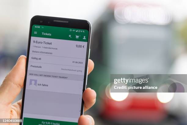 May 2022, Bavaria, Nuremberg: An employee of VAG presents a current test application of the VGN app for purchasing the 9-euro ticket. From June to...