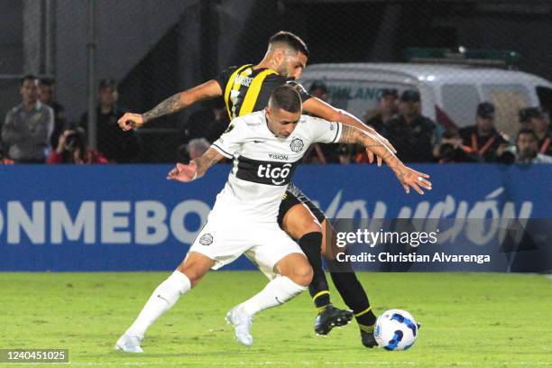 Derlis Gonzalez of Olimpia fights for the ball with Jorge Menos of Peñarol during a match between Olimpia and Peñarol as part of Copa CONMEBOL...