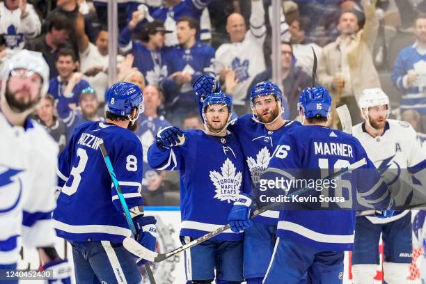 Alex Kerfoot of the Toronto Maple Leafs celebrates his goal against the Tampa Bay Lightning with teammates Jake Muzzin, TJ Brodie and Mitch Marner...