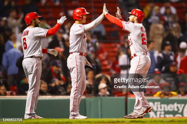 Jared Walsh of the Los Angeles Angels high fives Shohei Ohtani after hitting a three-run home run in the tenth inning of a game against the Boston...