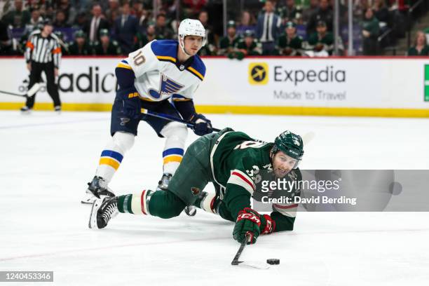 Brayden Schenn of the St. Louis Blues commits a tripping penalty against Ryan Hartman of the Minnesota Wild in the second period in Game Two of the...
