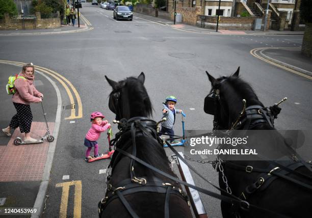 Children cross the street in front of a horse-drawn delivering different beers made by Windsor & Eton Brewery, in Windsor, England, on April 28th,...