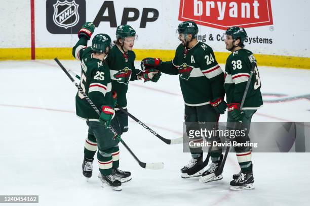 Kirill Kaprizov of the Minnesota Wild celebrates scoring an empty net goal against the St. Louis Blues for a hat trick with teammates in the third...