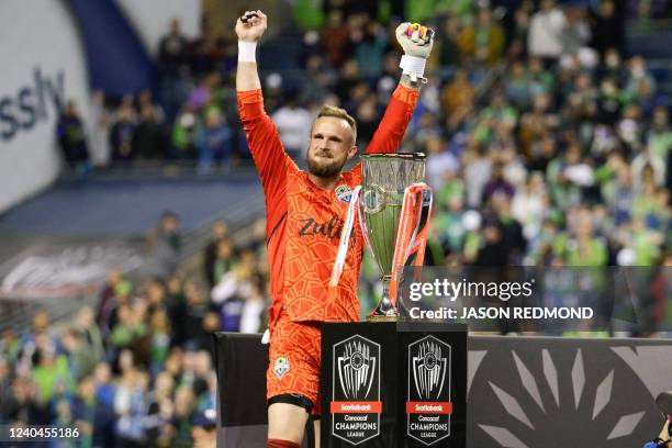 Seattle Sounders goalkeeper Stefan Frei celebrates next to the trophy after the Sounders won the CONCACAF Champions League final match between...