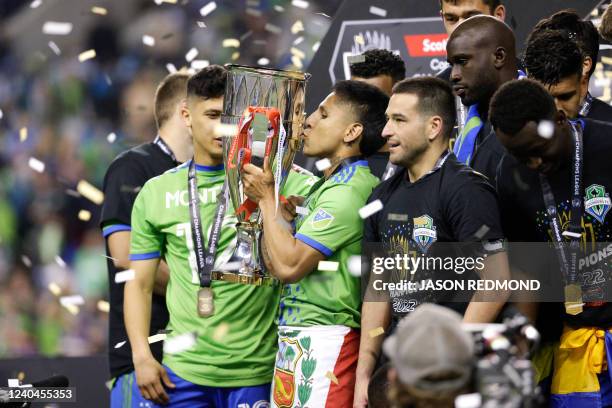 Seattle Sounders forward Raul Ruidiaz kisses the trophy as the team celebrates their victory in the CONCACAF Champions League final match between...