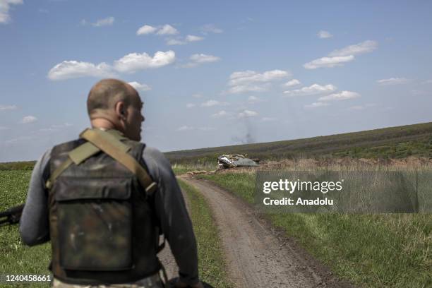 Ukrainian serviceman walks behind to the trenches as smoke rises from clashes against Russian troops near to Cherkaske City, on eastern Ukraine, May...