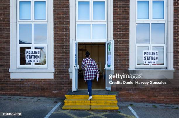 Polling card in hand, a woman makes her way into a polling station to cast her vote as voters head to polling stations to cast their ballots in local...