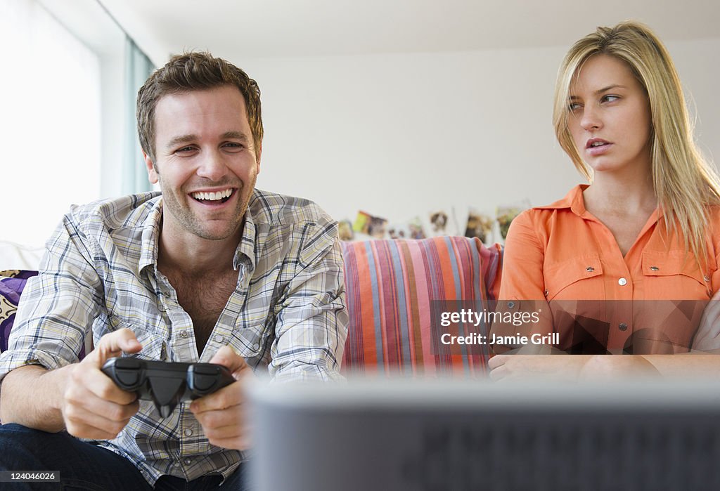 Girlfriend mat at boyfriend playing video game