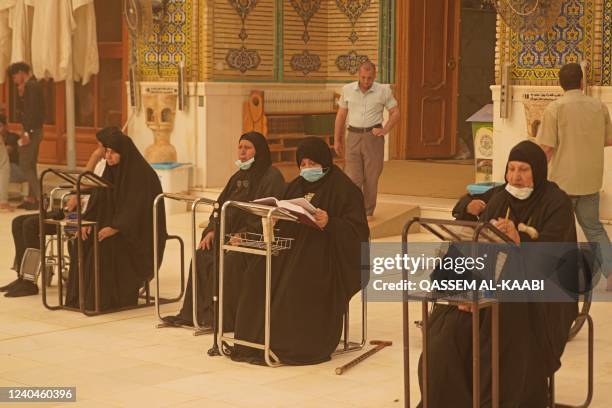 Iraqis pray at the Imam Ali shrine during a sandstorm in Iraq's holy city of Najaf on May 5, 2022. - Iraq is yet again covered in a thick sheet of...