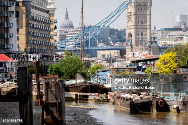 With the capital's financial district in the background, barges and lighters at Tower Bridge Moorings are grouped together on the river Thames, on...