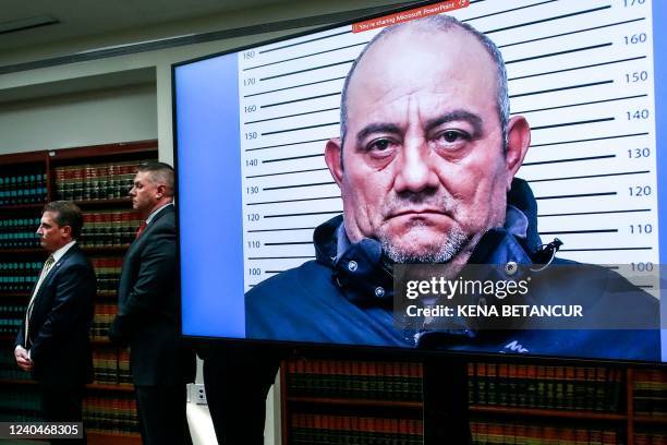 Picture of Colombian drug lord Dairo Antonio Usuga, aka Otoniel, is displayed on a screedn as Eastern District of New York Attorney Breon Peace...