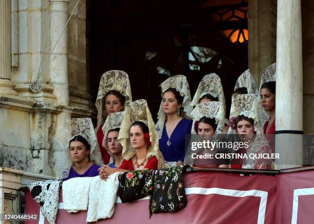 Women wearing traditional mantillas attend a bullfight during the Feria de Abril bullfighting festival at La Maestranza bullring in Seville on May 5,...