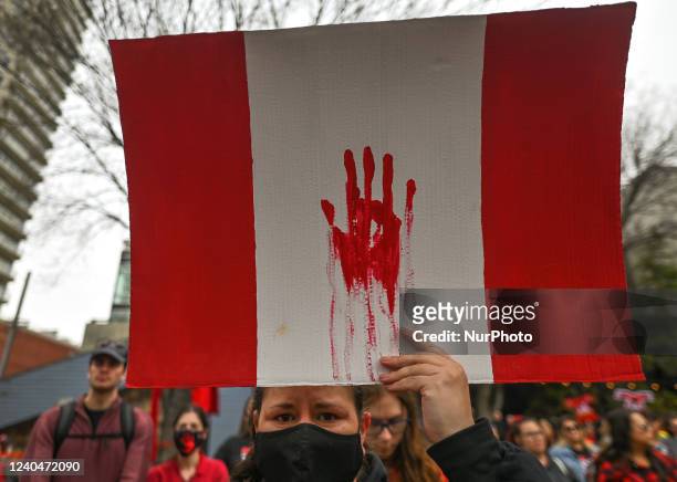 Participant holds a Canadian flag. Hundreds of women participated in the annual Red Dress Day march in downtown Edmonton, hosted by Project REDress,...