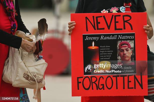 Participant holds a placard with an image of Jeremy Randall Nattress who was found stabbed to death inside a suite at the TraveLodge Edmonton East...