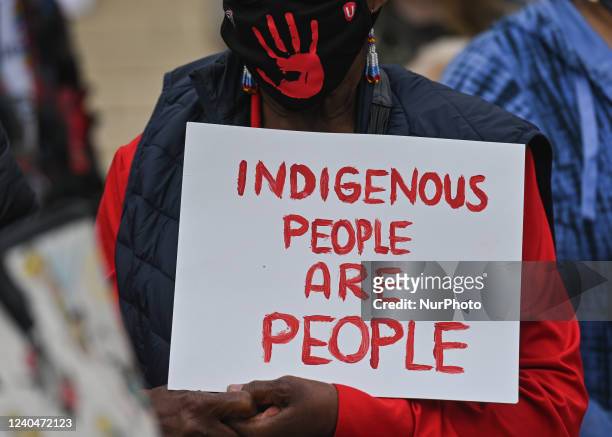 Participant holds a placard with words 'Indigenious People Are People'. Hundreds of women participated in the annual Red Dress Day march in downtown...