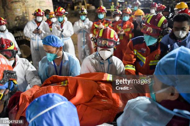 This photo taken early on May 5, 2022 shows rescuers carrying a survivor out of a collapsed six-storey building in Changsha, central Chinas Hunan...
