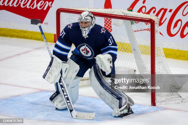 Goaltender Connor Hellebuyck of the Winnipeg Jets guards the net during first period action against the Calgary Flames at Canada Life Centre on April...