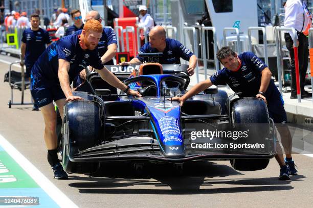 Crew members push the car of Williams Racing driver Alexander Albon of Thailand through the pit lane before the Crypto.com Miami Grand Prix on May 5,...