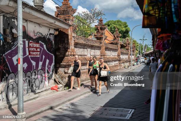Foreign tourists walk past clothing stores in Kuta, Bali, Indonesia, on Friday, May 6, 2022. With the broader reopening, fully vaccinated visitors...