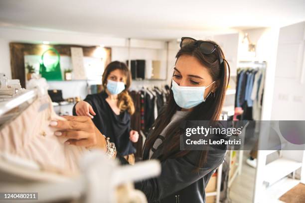 woman shopping protecting herself wearing protective mask - retail covid stock pictures, royalty-free photos & images
