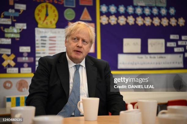 Britain's Prime Minister Boris Johnson reacts as he visits the Field End Infant school, in South Ruislip, on May 6, 2022. - Prime Minister Boris...