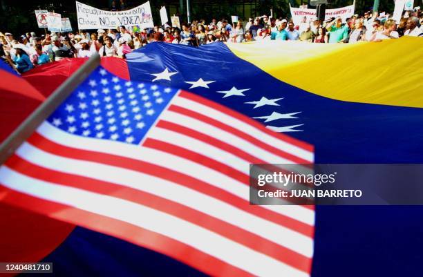 Hundreds of Venezuelans take part in a demonstration before the Venezuelan and US national flags 22 September 2001 in Caracas honoring the victims of...