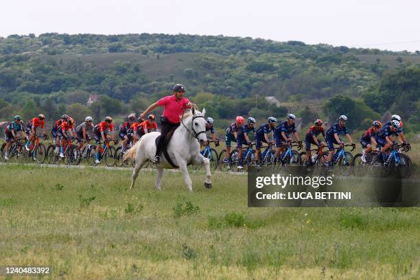 Man on horseback escorts riders during the first stage of the Giro d'Italia 2022 cycling race, 195 kilometers between Budapest and Visegrad, Hungary,...