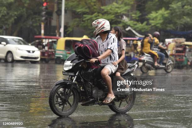 Commuters out in the rain, at Sector 19 on May 6, 2022 in Noida, India. The national capital region received 'very light' to 'light' rain due to...
