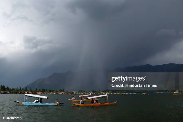 Tourists enjoy Shikara boat ride as dark clouds loom over Dal Lake during an impending rainfall on May 6, 2022 in Srinagar, India.