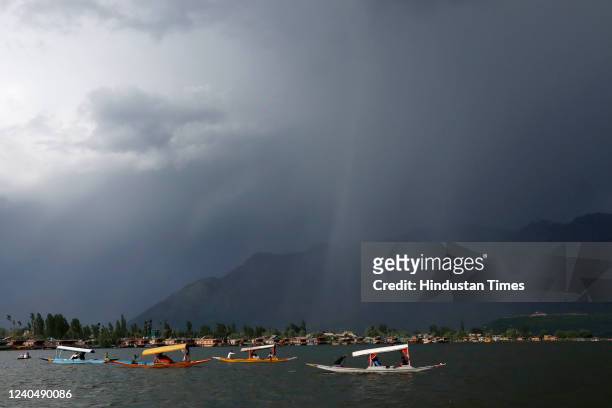 Tourists enjoy Shikara boat ride as dark clouds loom over Dal Lake during an impending rainfall on May 6, 2022 in Srinagar, India.