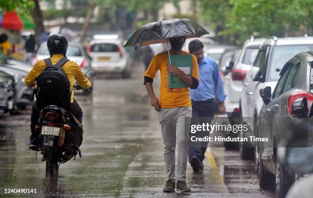 Commuters out in the rain at Connaught Place on May 6, 2022 in New Delhi, India. The national capital region received 'very light' to 'light' rain...