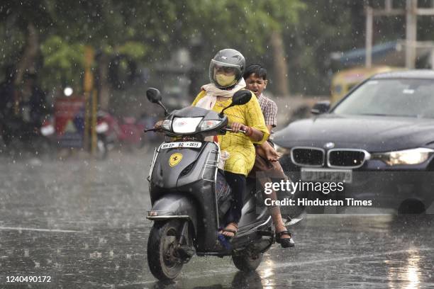 Commuters out in the rain, at Sector 19 on May 6, 2022 in Noida, India. The national capital region received 'very light' to 'light' rain due to...