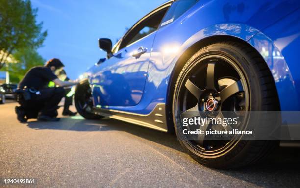 May 2022, Lower Saxony, Hanover: Police officers check a tuned vehicle at the Expo Park. Once again, hundreds of car tuners and car fans met on the...