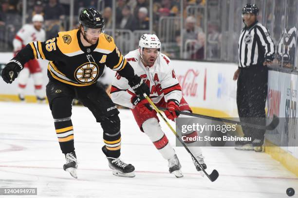 Brandon Carlo of the Boston Bruins skates against Jordan Martinook of the Carolina Hurricanes in Game Three of the First Round of the 2022 Stanley...