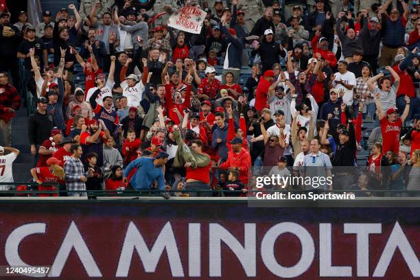 Los Angeles Angels fan holds up a home run ball hit by right fielder Taylor Ward during a regular season MLB game between the Los Angeles Angels and...