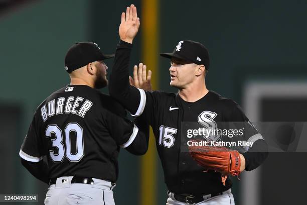 Adam Engel high fives teammate Jake Burger of the Chicago White Sox after beating the Boston Red Sox at Fenway Park on May 6, 2022 in Boston,...