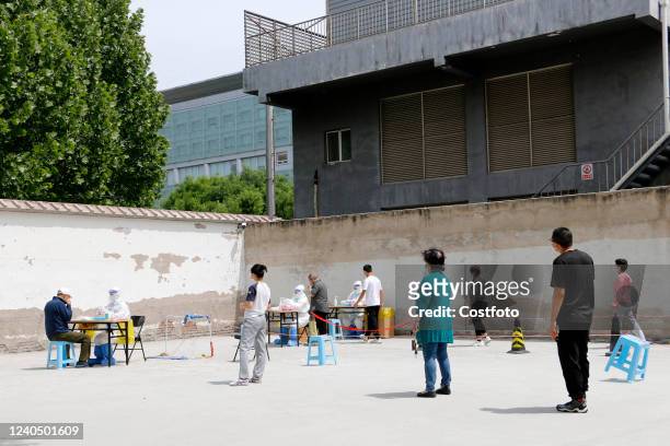 Citizens line up to take nucleic acid testing in Baiduizi community, a temporary control area in Haidian District, Beijing, May 7, 2022.