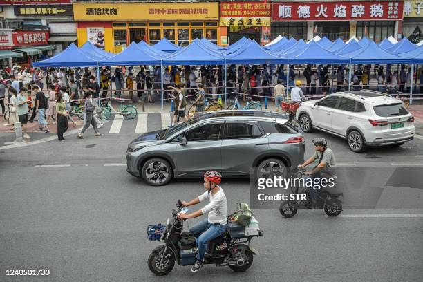 Residents queue to undergo nucleic acid tests for the Covid-19 coronavirus in Guangzhou, in China's southern Guangdong province on May 7, 2022. -...