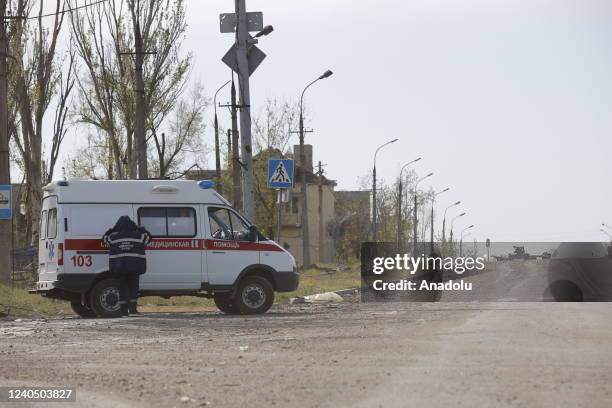 An ambulance waits on the side of the road during several dozen Ukrainian civilians, who had been living in the bomb shelters of the Azovstal plant...