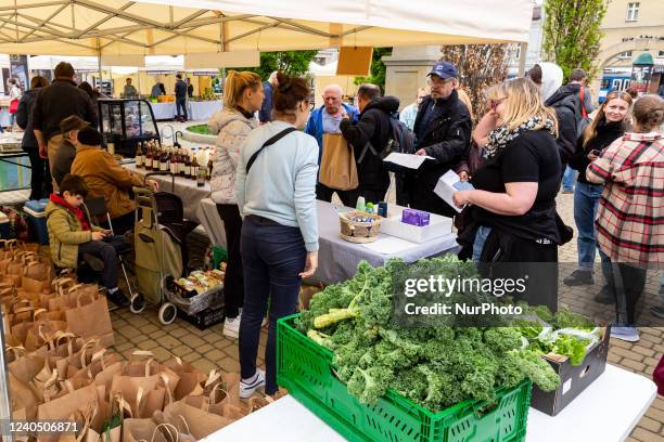 Ukrainian refugees show their status documents as they queue to receive fresh food packs from volunteers of 'Parsley Market' Foundation at Parsley...