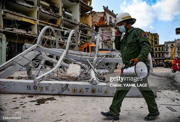 Firefighter walks next to the ruins of the Saratoga Hotel, in Havana, on May 7, 2022. - The death toll after an explosion ripped through a luxury...