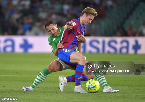 Barcelona's Dutch midfielder Frenkie De Jong vies with Real Betis' Mexican midfielder Andres Guardado during the Spanish League football between Real...