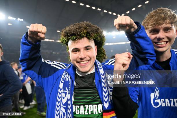 Schalke's supporters celebrate the victory of their team on the pitch after the German second division Bundesliga football match between FC Schalke...