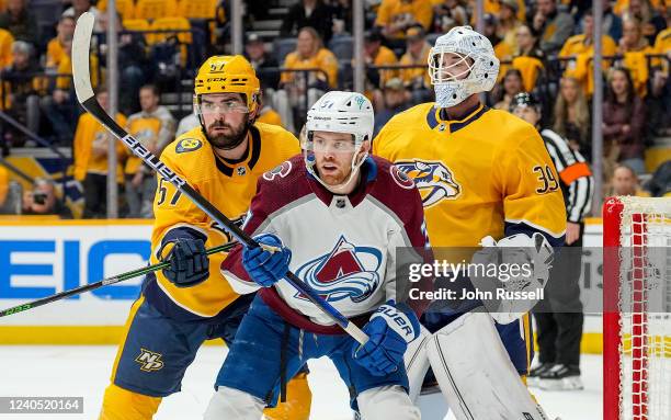 Compher of the Colorado Avalanche battles in front of the net against Dante Fabbro and Connor Ingram of the Nashville Predators in Game Three of the...