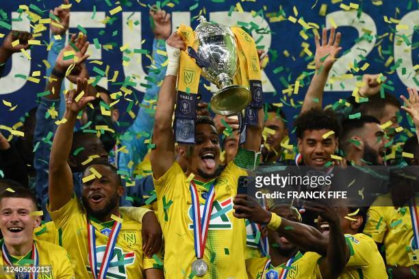 Nantes' French midfielder Ludovic Blas holds the Cup as he celebrates with teammtes during the trophy ceremony after winning the French Cup final...