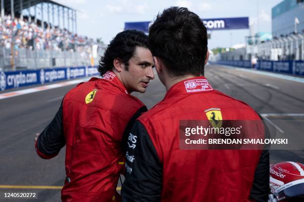 Ferrari's Spanish driver Carlos Sainz speaks with teammate Monegasque driver Charles Leclerc after qualifying in the Miami Formula One Grand Prix at...
