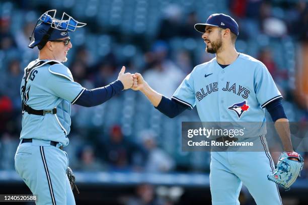 Zack Collins and Julian Merryweather of the Toronto Blue Jays celebrate an 8-3 win against the Cleveland Guardians in game one of a doubleheader at...